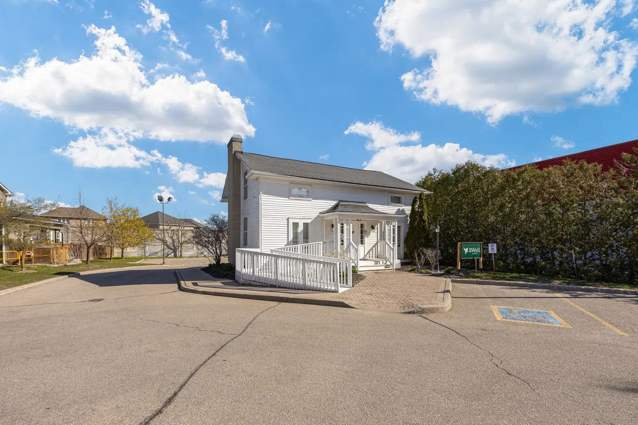 The BWell Lounge house at 75 Dawson Manor Blvd seen across its parking lot, with the porch, the ramp and the BWell sign