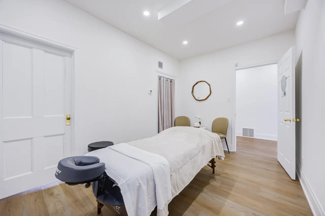 A room at BWell Lounge with a table, two chairs and a round mirror