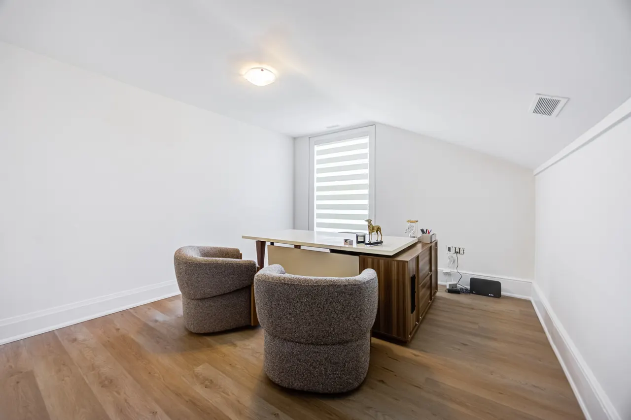 An office at BWell Lounge with a desk and two taupe bouclé chairs