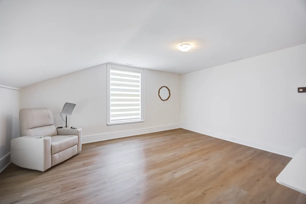 A quiet room with a cream recliner beside a window